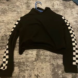 A black cropped hoodie with white checkered sleeves